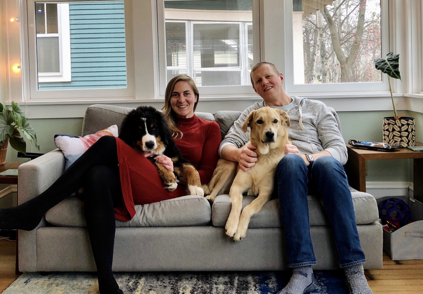 Martin and Katie on the couch in their first home with Rocket and puppy Ruby